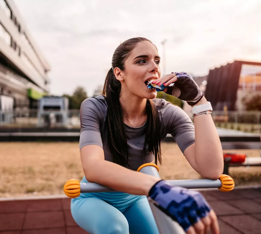 Kvinne spiser Herbalife24 Achieve Proteinbar